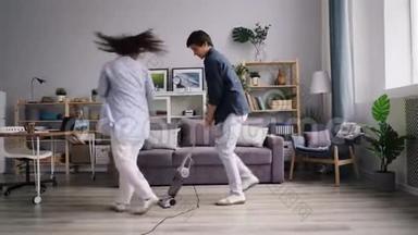男人打扫地板，吸尘器和女朋友跳舞，玩得开心